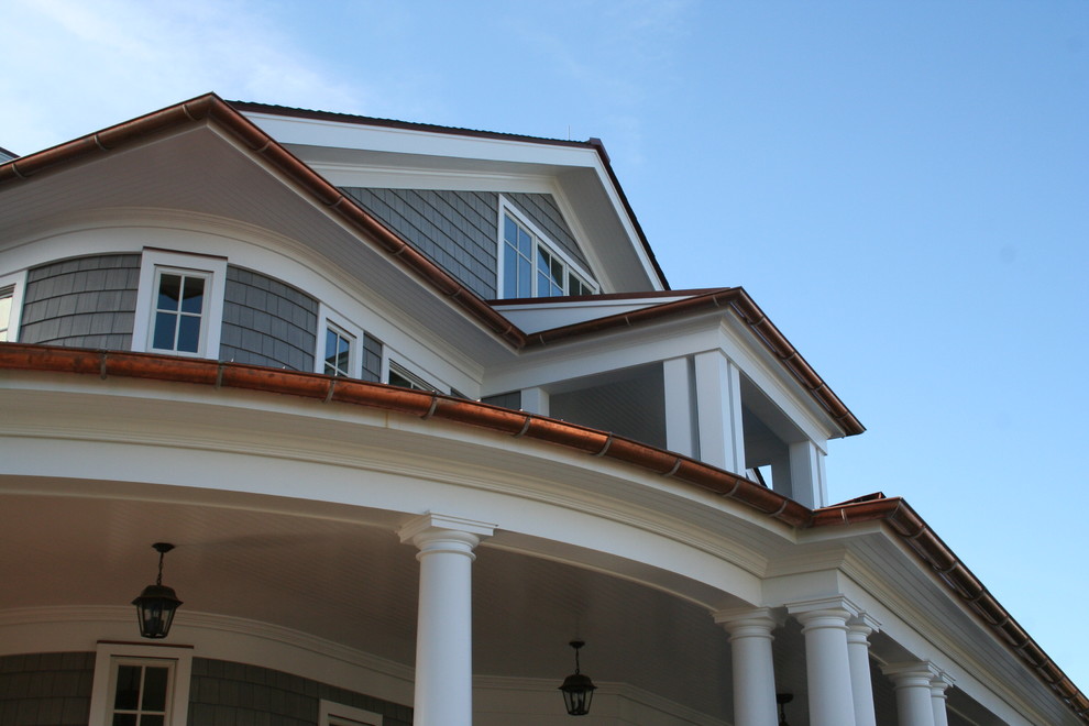 Imagen de fachada de casa gris clásica grande de tres plantas con revestimiento de vinilo, tejado a dos aguas y tejado de metal