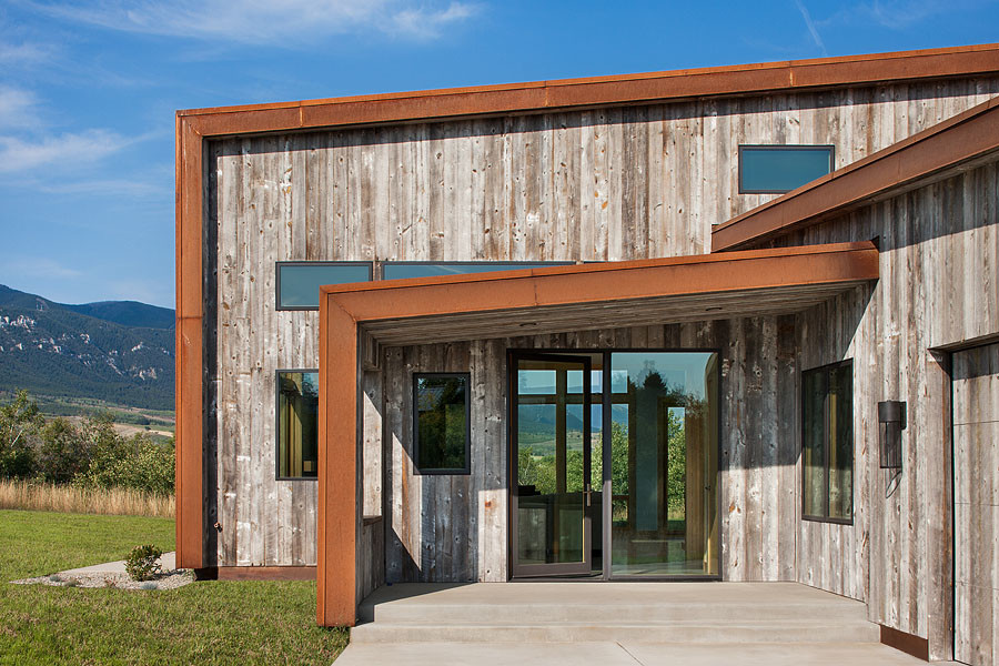 Imagen de fachada de casa gris moderna de tamaño medio de dos plantas con tejado de un solo tendido, tejado de metal y revestimientos combinados