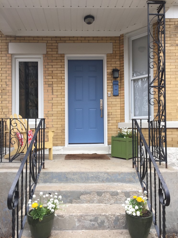 Foto della facciata di una casa piccola gialla american style a due piani con rivestimento in mattoni