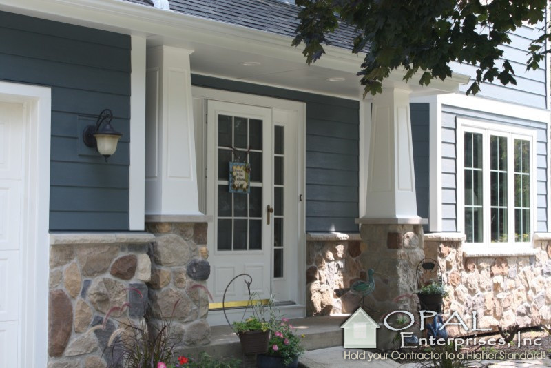 Foto della facciata di una casa blu classica con rivestimenti misti
