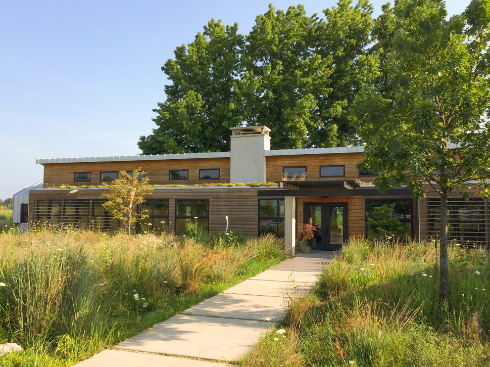 Exemple d'une grande façade de maison marron moderne en bois de plain-pied avec un toit en métal et un toit en appentis.