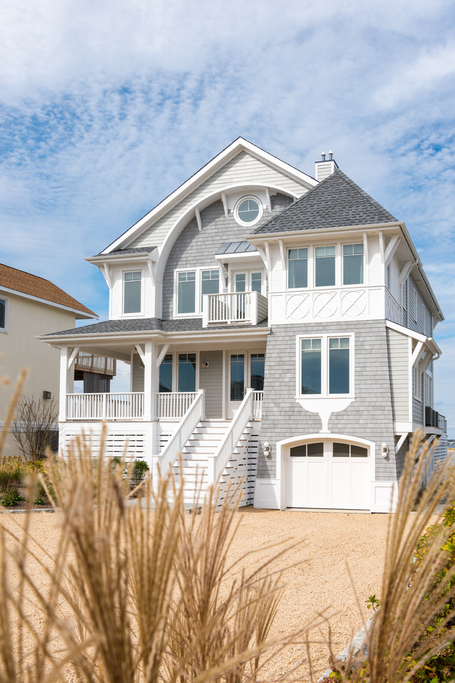 This is an example of a medium sized and gey coastal detached house in New York with three floors, mixed cladding, a pitched roof and a shingle roof.