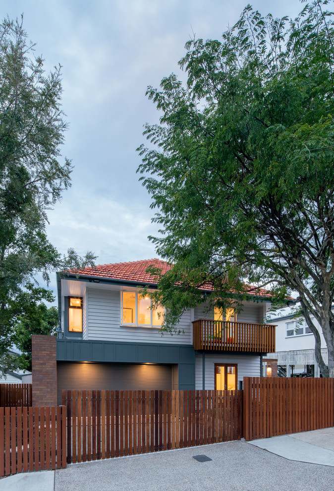 На фото: двухэтажный, серый дом в стиле модернизм с двускатной крышей с