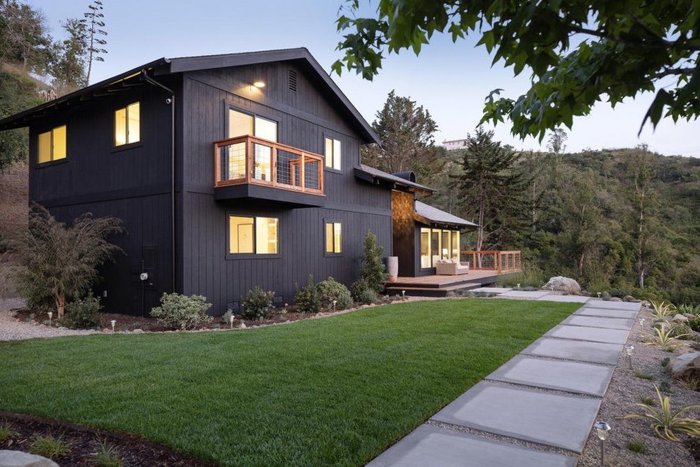 Inspiration pour une façade de maison noire minimaliste en bois de taille moyenne et à un étage avec un toit à deux pans et un toit en shingle.