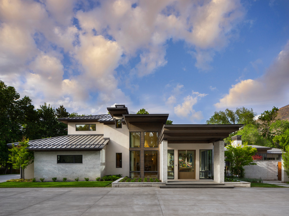 Inspiration for a large contemporary white two-story concrete house exterior remodel in Salt Lake City with a shed roof and a metal roof