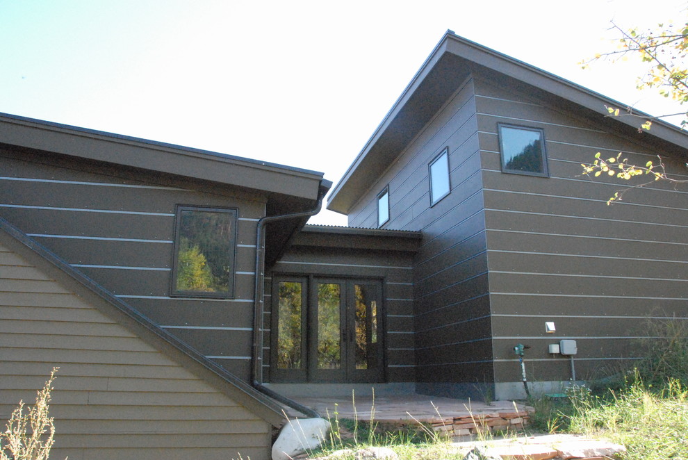 Mid-sized trendy brown two-story concrete fiberboard exterior home photo in Denver with a shed roof