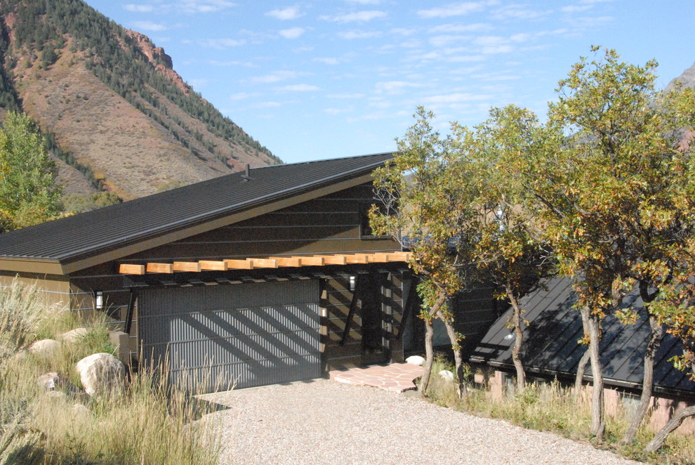 Photo of a medium sized and brown contemporary two floor glass house exterior in Denver with a lean-to roof.