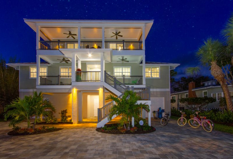 Inspiration for a medium sized and beige beach style detached house in Miami with three floors, vinyl cladding, a half-hip roof and a shingle roof.
