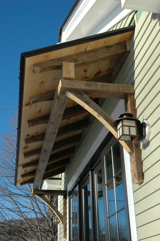 Cette photo montre une façade de maison beige tendance en panneau de béton fibré de taille moyenne et à un étage avec un toit à deux pans.