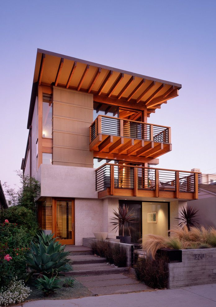 Exemple d'une façade de maison beige tendance à deux étages et plus avec un toit plat.