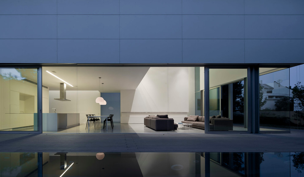 Réalisation d'une grande façade de maison grise minimaliste en béton à un étage avec un toit plat.
