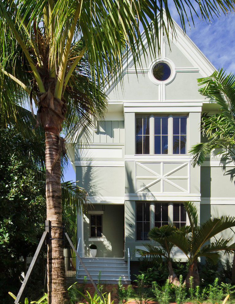 Diseño de fachada tropical de tamaño medio de tres plantas con tejado a dos aguas