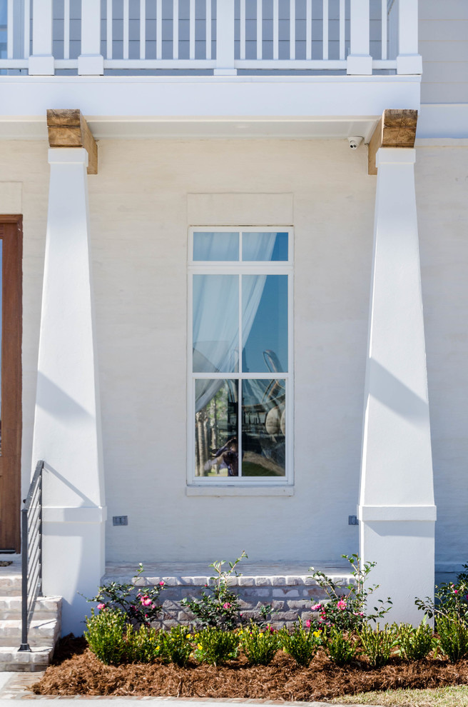 Foto della facciata di una casa bianca classica a due piani di medie dimensioni con rivestimento in mattoni