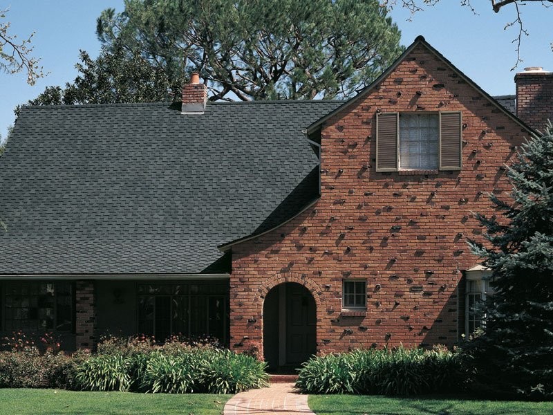 Foto della facciata di una casa grande marrone classica a due piani con rivestimento in mattoni
