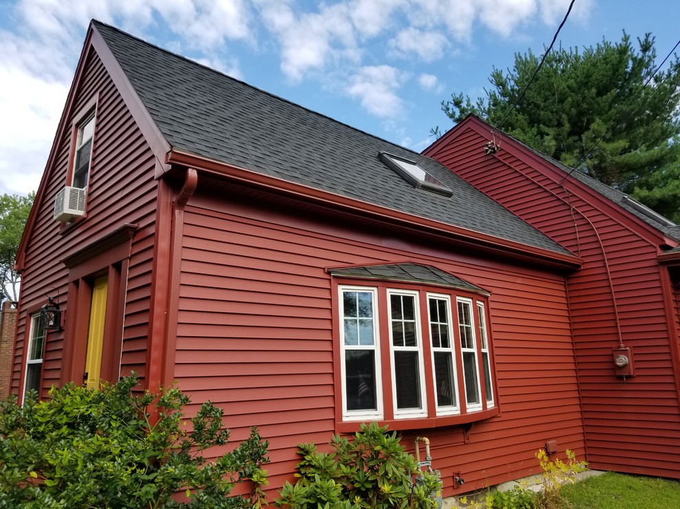 Aménagement d'une façade de maison rouge montagne de taille moyenne et à un étage avec un revêtement en vinyle, un toit à deux pans et un toit en shingle.