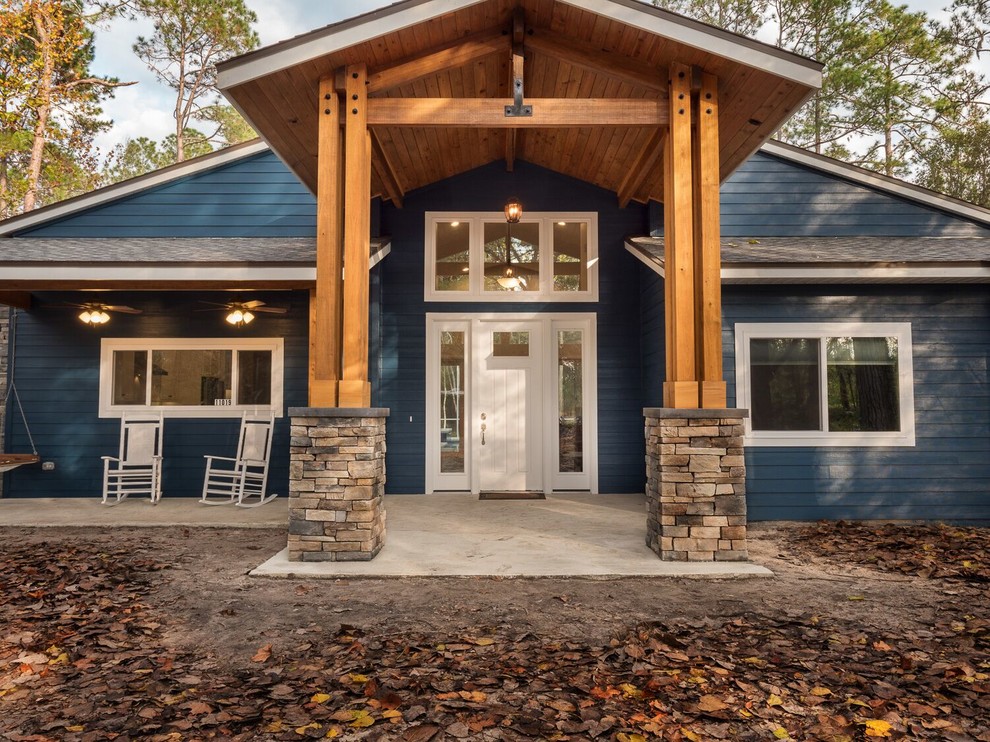 Diseño de fachada de casa azul de estilo americano de tamaño medio de una planta con revestimientos combinados, tejado a dos aguas y tejado de teja de madera