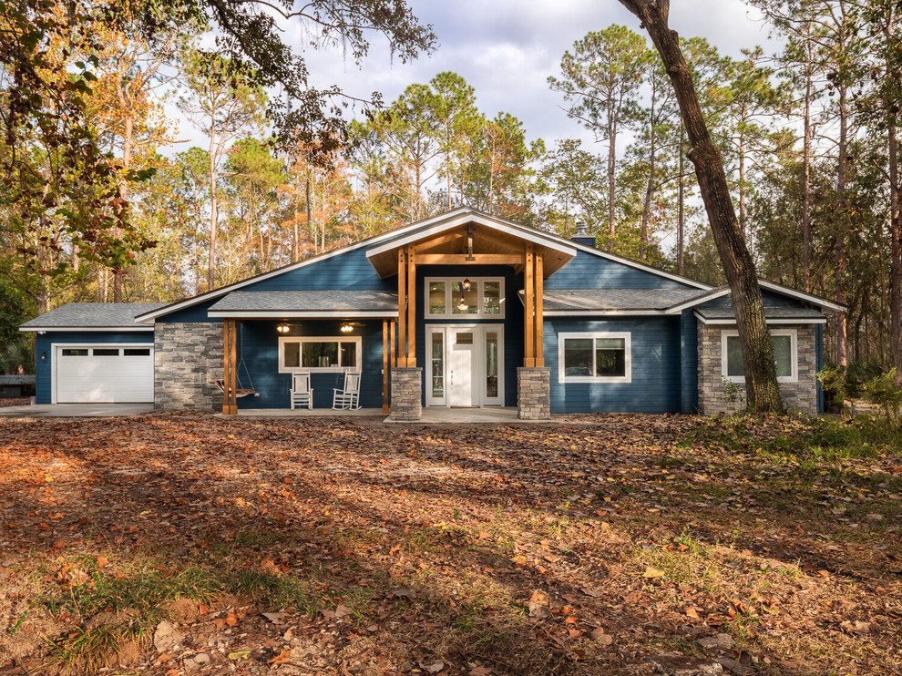 Modelo de fachada de casa azul de estilo americano de tamaño medio de una planta con revestimientos combinados, tejado a dos aguas y tejado de teja de madera