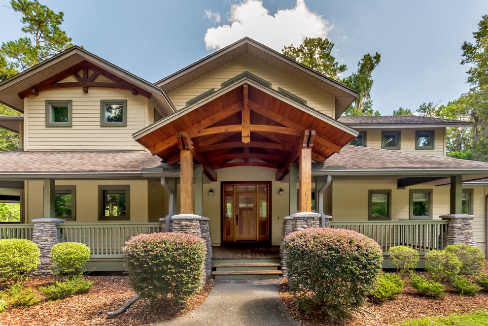 Large craftsman beige two-story stucco exterior home idea in Other with a shingle roof