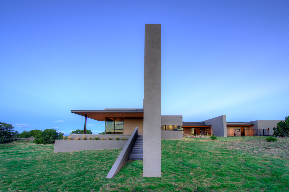 Großes, Einstöckiges Modernes Haus mit Lehmfassade, grauer Fassadenfarbe und Flachdach in Albuquerque