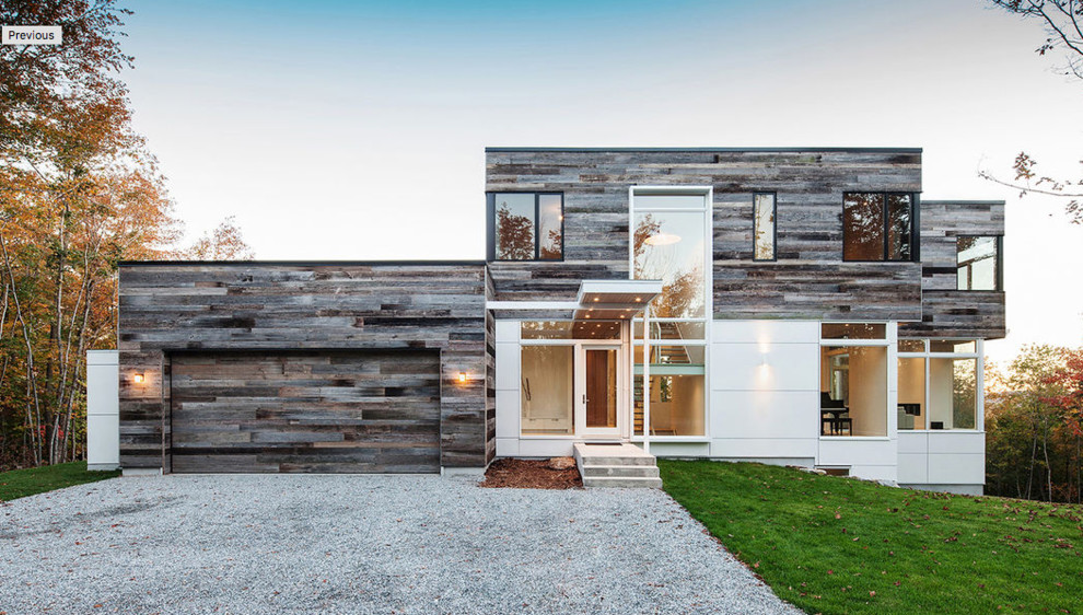 Imagen de fachada de casa gris contemporánea de dos plantas con revestimientos combinados y tejado plano