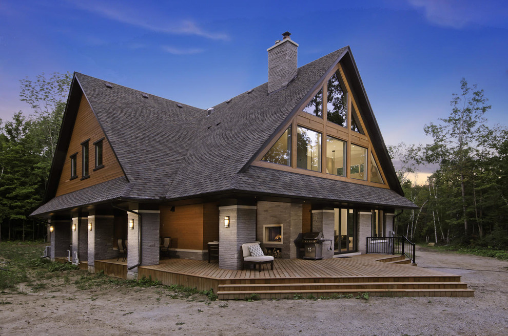 Стильный дизайн: большой, двухэтажный, коричневый частный загородный дом в классическом стиле с комбинированной облицовкой, двускатной крышей и крышей из гибкой черепицы - последний тренд