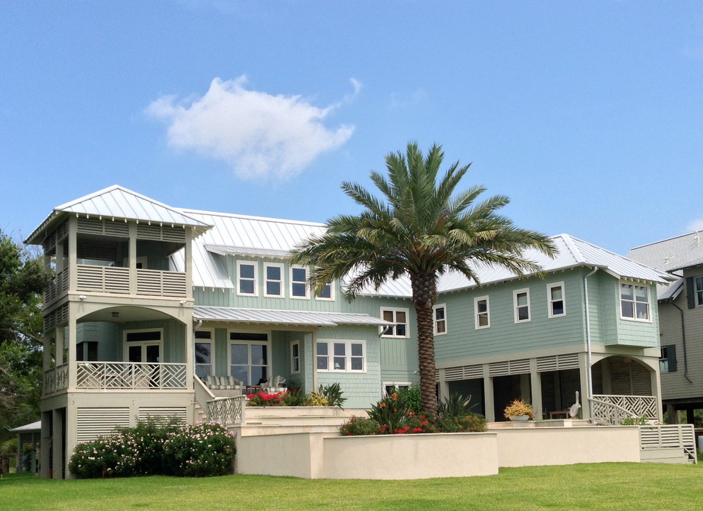 Стильный дизайн: большой, трехэтажный, деревянный, синий частный загородный дом в морском стиле с двускатной крышей и металлической крышей - последний тренд