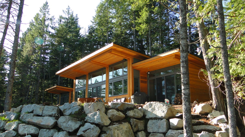 Inspiration pour une très grande façade de maison marron design en bois de plain-pied avec un toit plat.