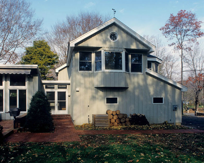 Aménagement d'une façade de maison grise contemporaine en bois de taille moyenne et à un étage.