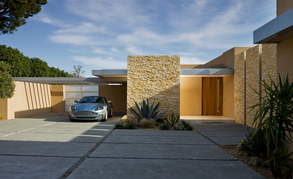 Cette photo montre une grande façade de maison jaune moderne de plain-pied avec un revêtement mixte et un toit plat.