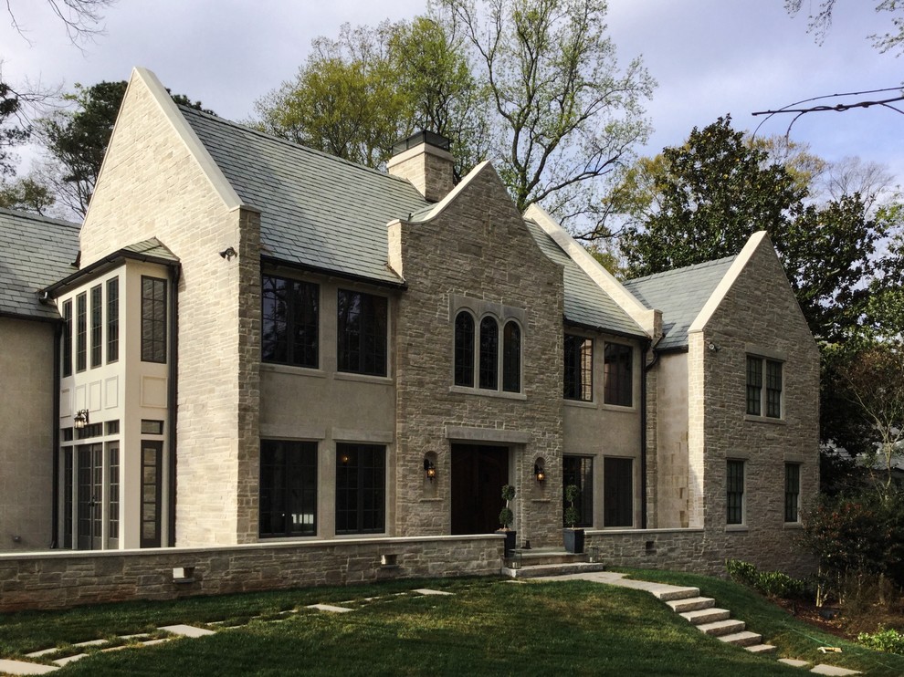 Ispirazione per la facciata di una casa beige industriale a due piani di medie dimensioni con rivestimento in pietra e tetto a capanna