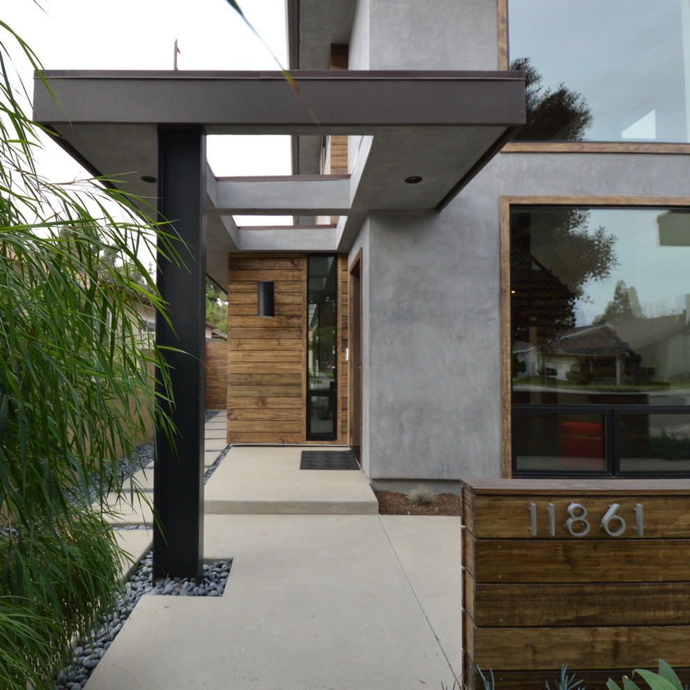 Esempio della facciata di una casa grigia moderna a due piani di medie dimensioni con rivestimenti misti e tetto piano