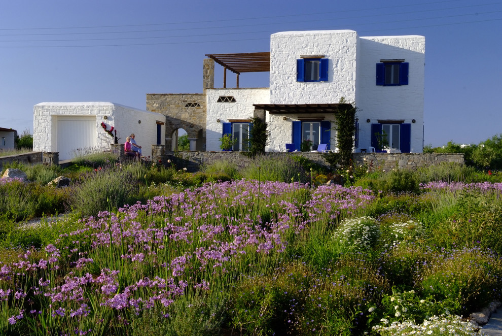 На фото: двухэтажный дом среднего размера в средиземноморском стиле с облицовкой из камня