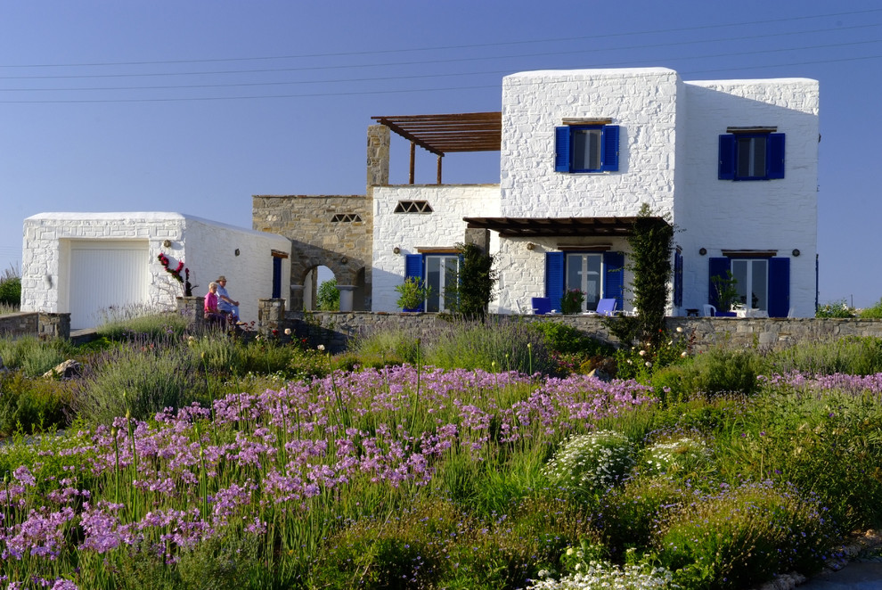 Imagen de fachada mediterránea de tamaño medio de dos plantas con revestimiento de piedra