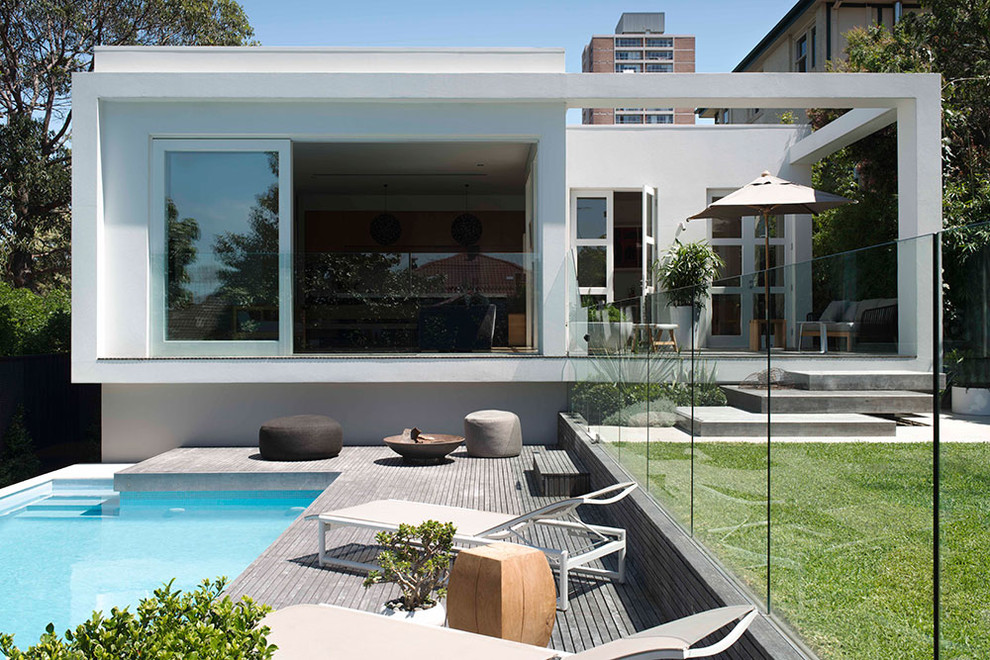 Réalisation d'une petite façade de maison blanche minimaliste de plain-pied avec un toit plat.
