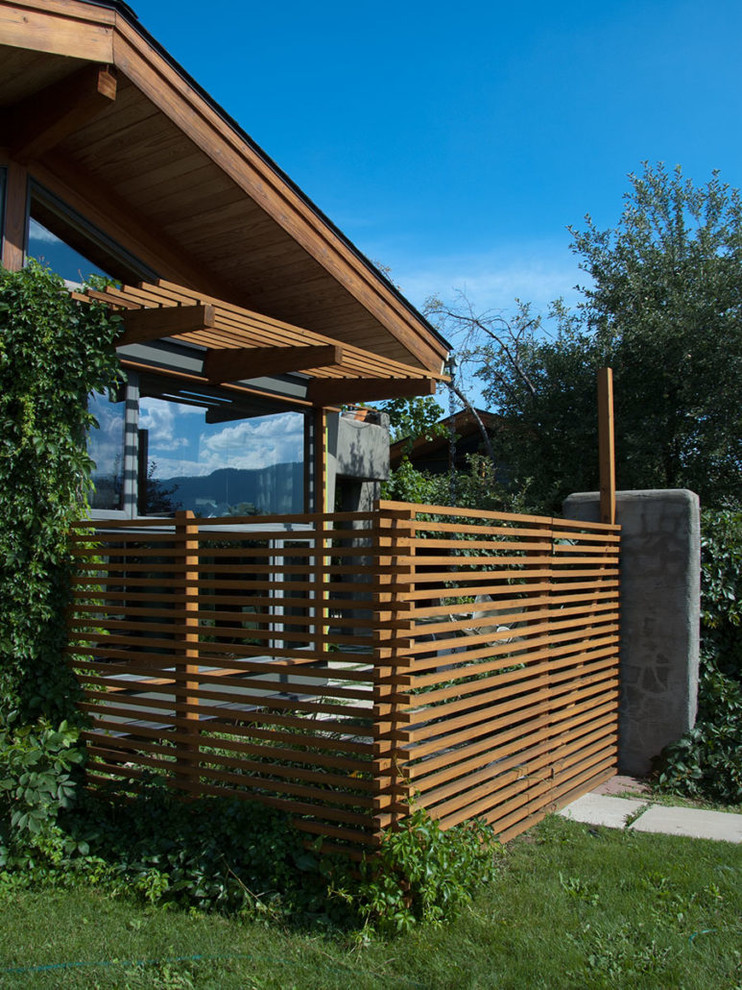 Diseño de fachada de casa gris moderna de tamaño medio de tres plantas con revestimiento de estuco y tejado a dos aguas
