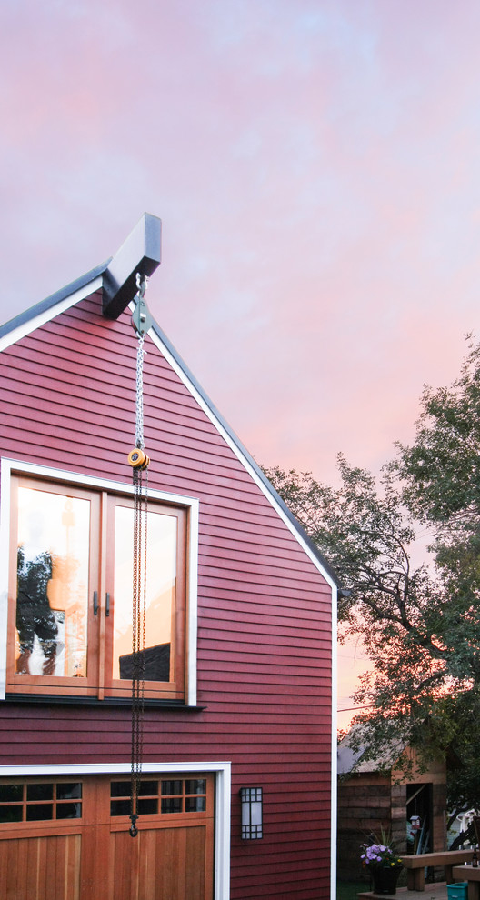 Esempio della facciata di una casa piccola rossa scandinava a due piani con rivestimento in legno