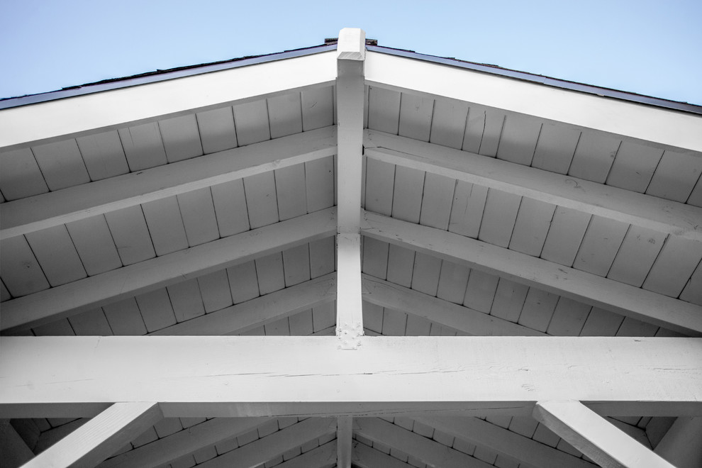 Ejemplo de fachada de piso gris marinera pequeña de una planta con revestimiento de estuco, tejado a dos aguas y tejado de teja de madera