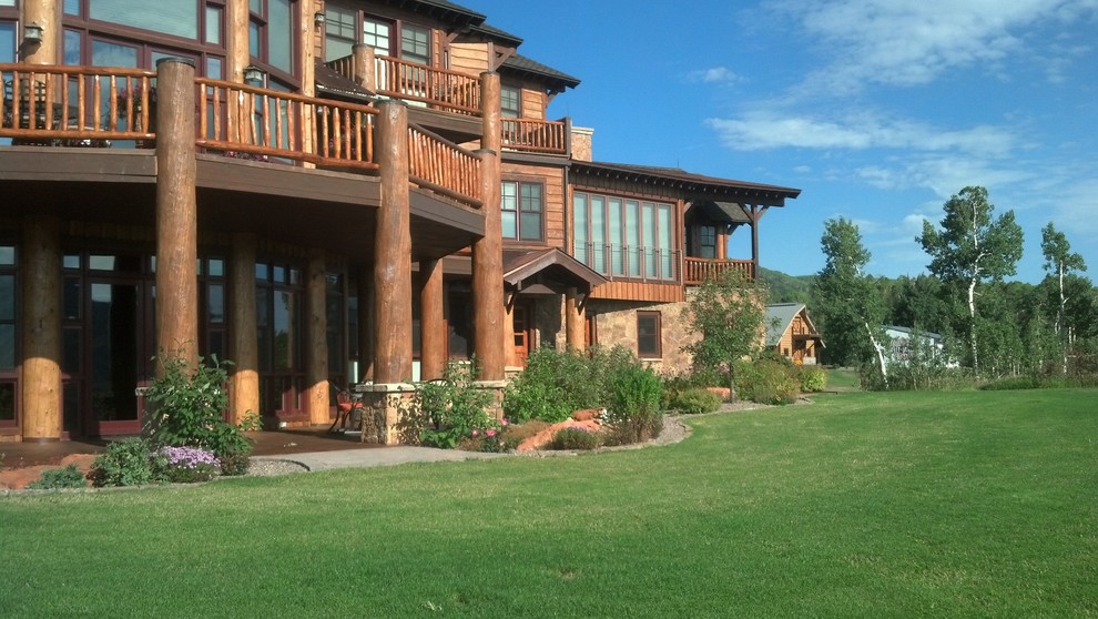 Large rustic brown three-story wood exterior home idea in Denver with a shingle roof
