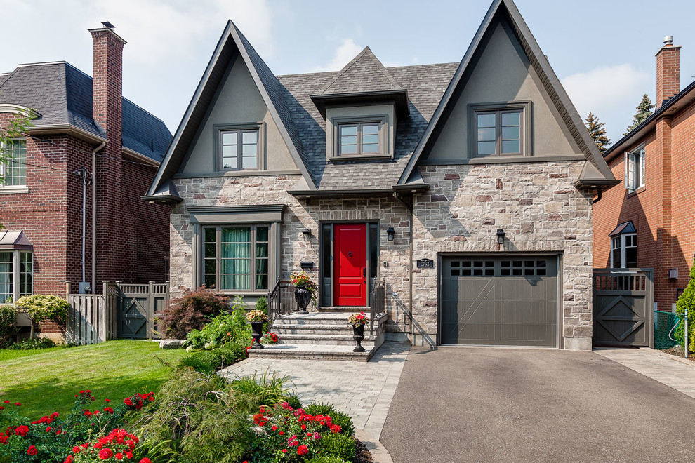 Medium sized and gey classic two floor house exterior in Toronto with stone cladding.