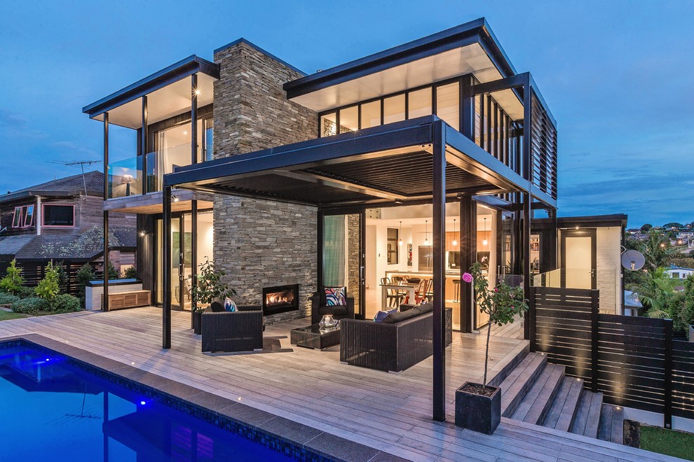 Mid-sized trendy black two-story stone flat roof photo in Auckland