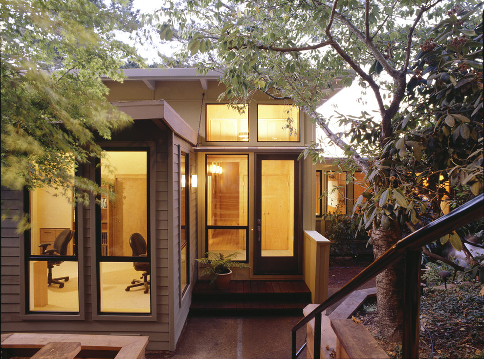 Aménagement d'une petite façade de maison verte rétro en bois de plain-pied.