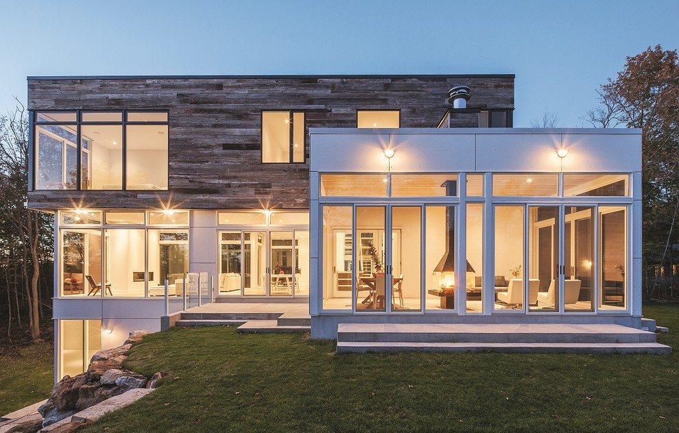 Cette image montre une grande façade de maison blanche minimaliste en bois à deux étages et plus avec un toit plat.