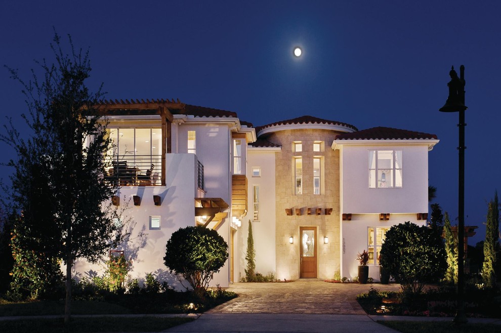 Diseño de fachada de casa blanca mediterránea grande de dos plantas con revestimiento de estuco y tejado de teja de barro