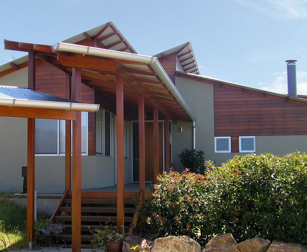 Foto della facciata di una casa grande beige contemporanea a un piano con rivestimento in legno e copertura in metallo o lamiera