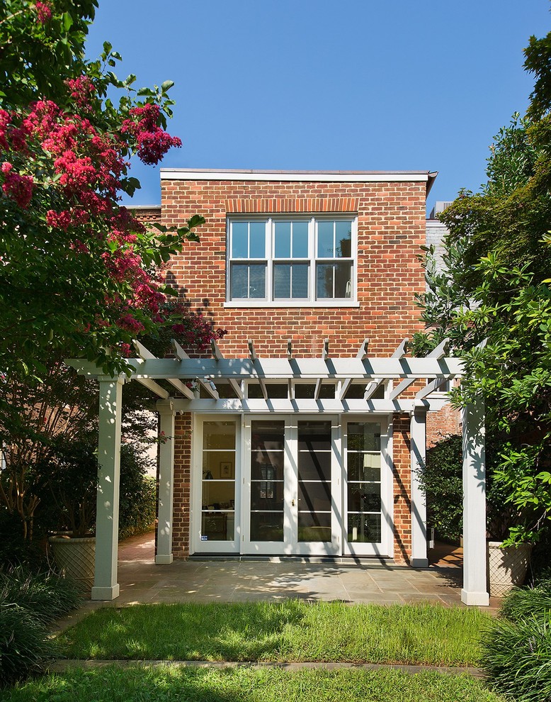 Immagine della facciata di una casa classica a due piani di medie dimensioni con rivestimento in mattoni e tetto piano