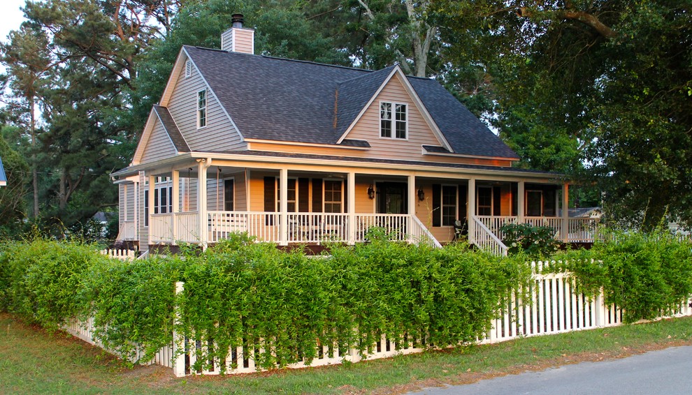 Ejemplo de fachada beige de estilo de casa de campo de tamaño medio de dos plantas con revestimiento de madera