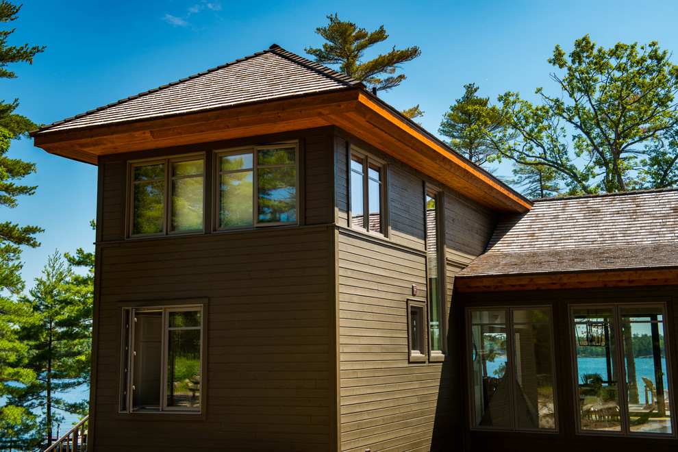 Photo of a medium sized and brown rustic two floor detached house in Toronto with wood cladding, a pitched roof and a shingle roof.