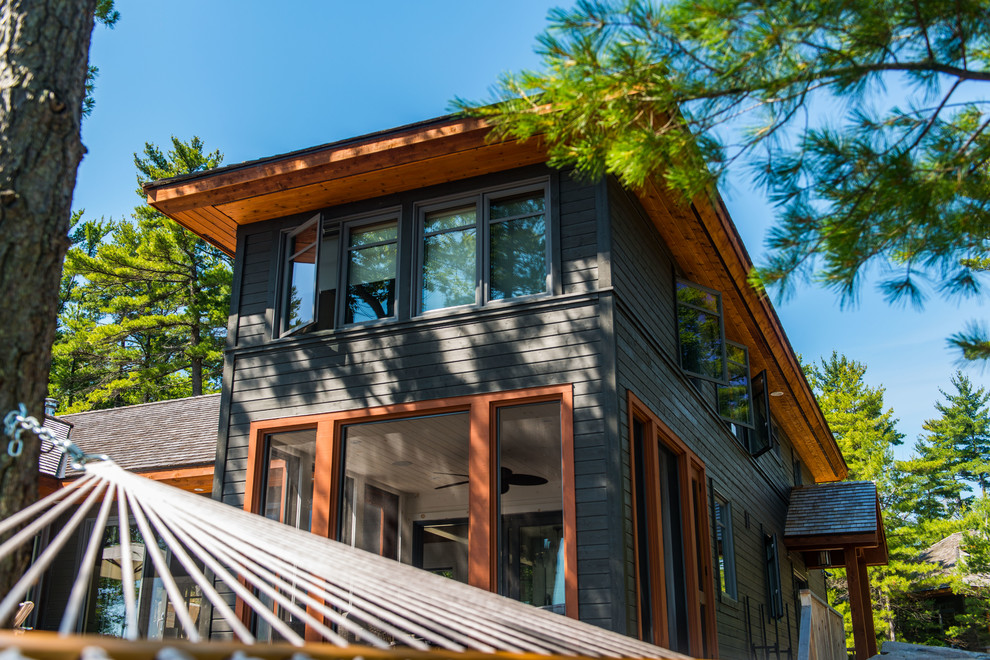 Modelo de fachada de casa marrón rústica de tamaño medio de dos plantas con revestimiento de madera, tejado a dos aguas y tejado de teja de madera