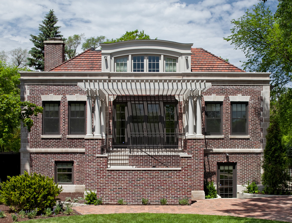 Idée de décoration pour une façade de maison rouge tradition en brique à un étage avec un toit en appentis.