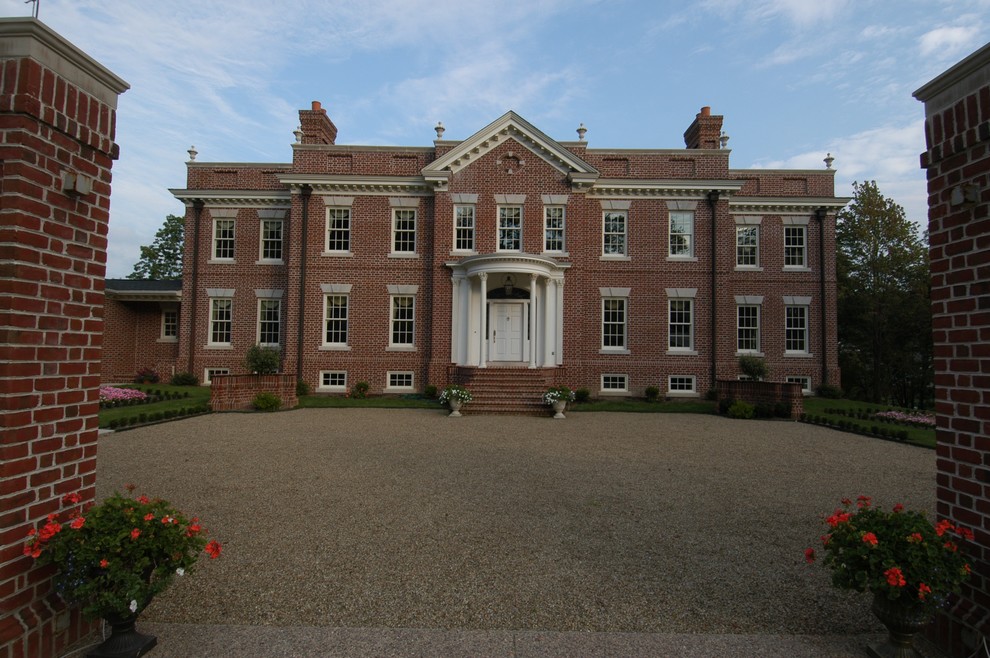Immagine della facciata di una casa grande classica a due piani con rivestimento in mattoni